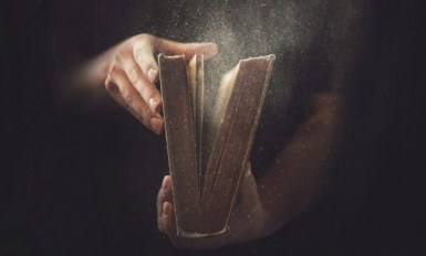Holding an open book with dust coming out.